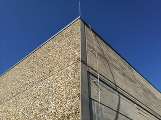 Zweckbau im Stil der Sechzigerjahre und Siebzigerjahre aus Waschbeton vor blauem Himmel im...