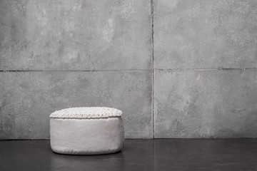 white soft padded stool on grey with copy space