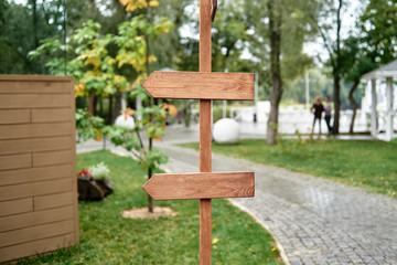 Blank vintage wedding signs in garden, copy space. Empty wood arrows in park, free space