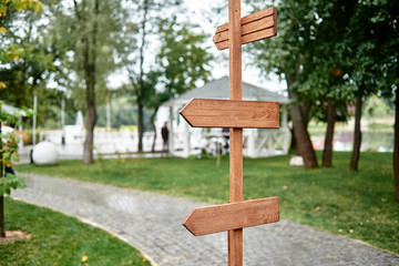 Blank vintage wedding signs in garden, copy space. Empty wood arrows in park, free space