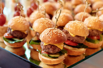 Buffet table with mini hamburgers at luxury wedding reception, copy space. Serving food and appetizers at restaurant. Catering banquet table - obrazy, fototapety, plakaty