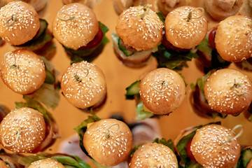 Top view of buffet table with mini hamburgers at luxury wedding reception, copy space. Serving food...