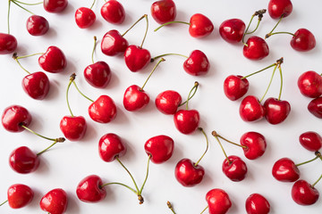Fresh cherries scattered on white. Cherries on a white background. Fresh cherry. Cherry fruit. Cherries with copy space for text. Top view. Background of cherries.Sprinkled cherry on white background.