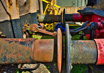The rusty buffers of two old railway cars collide, transport