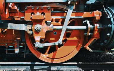 Close-up of the drive wheels and the drive rod of a historic steam locomotive
