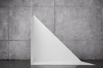 triangle shape carton near grey wall with copy space