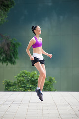 Fototapeta premium Fitness girl exercising outdoor in urban city architecture, stretching legs, doing squash, push-buttons, jumps, resting, smiling athlete body