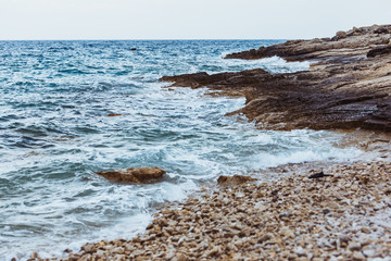 Fototapeta na wymiar view of rocky sea beach in storm weather