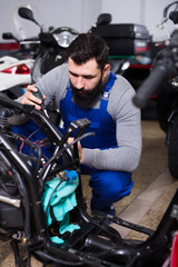 Obraz na płótnie Canvas Worker repairing motorbike
