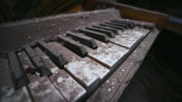Close-up detail view of old abandoned piano destroyed by time in past auditorium in Prypiat city. View inside the destroyed building of theatre with piano in Chernobyl exclusion zone.