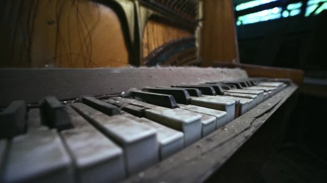 Close-up of old dirty useless piano with radiation inside the old theatre of ghost town Prypiat. Walking inside abandoned buildings in dead city of Chernobyl, Ukraine.