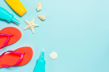 Summer beach sea accessories. Coral flip flops, shells, starfish, yellow sunscreen bottle, body...