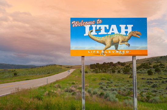 Dinosaur on Welcome to Utah sign along road, Utah, United States