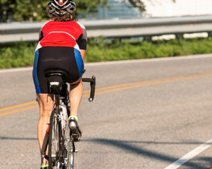 Cyclist training on a road racing bike from behind