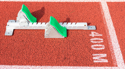 Green sprinters starting blocks on the 400 meter start line