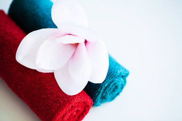 Colored towels and orchid on white table with copy space on bath room background.