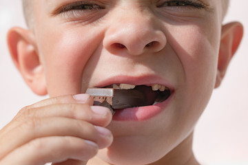 Little boy eating a chocolate bar