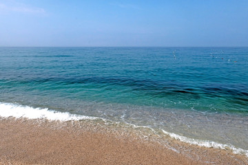 Fototapeta na wymiar Sunny sandy beach with sea waves. Tropical landscape. Coast sea or ocean. Beautiful background.