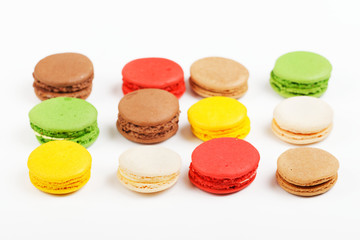 Macarons on a white background. Multicolored sweet macarons laid out in rows.