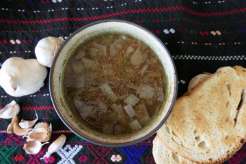 Warm Homemade Lentils Soup with Garlic and Bread Slices on a Dark Background