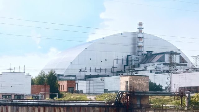 Chernobyl nuclear power station with a new protective white shelter over the remains of destroyed reactor unit 4. View of impressive power plant construction in the exclusion zone on north of Ukraine