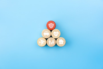 Insurance concept. Wooden blocks with insurance icons. family, life, car, travel, health and house insurance icons. blue background with copy space, minimal