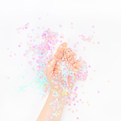 Naklejka premium Pearl pastel confetti sparkles with woman hand