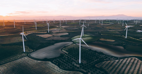 Aerial view of windmills station with rotating propellers generating alternative clean green power...