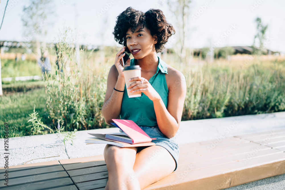 Poster attractive dark skinned hipster girl sitting in park with caffeine beverage and knowledge textbook c
