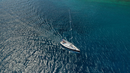 Aerial drone photo of beautiful wooden deck sail boat cruising the deep blue sea of Mykonos island, Cyclades, Greece