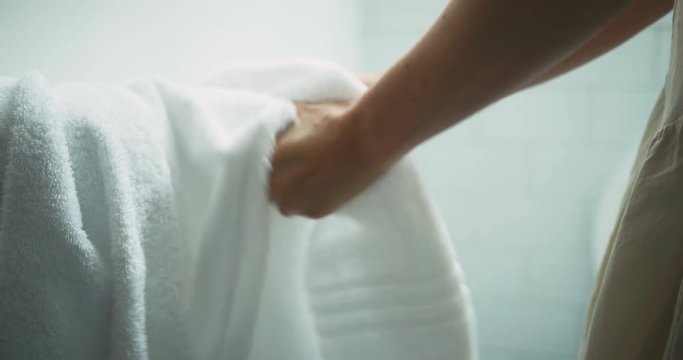 Young woman drying her hands on towel in the bathroom