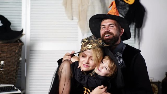 Happy family celebrates halloween. Halloween party concept. People wearing carnival costumes. Happy Halloween. Family traditions. Little boys hugging mom. Cute boy with parents. Love and tenderness.