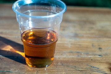 Plastic glass with beer on a wooden table