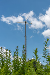 wind turbine in field with blue sky and clouds