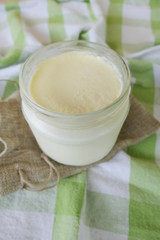 Homemade Yoghurt in a Jar on a Traditional Green Checkered Background