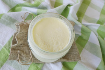 Homemade Yoghurt in a Jar on a Traditional Green Checkered Background