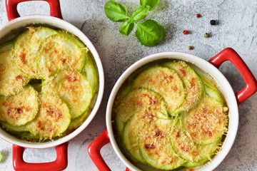 Zucchini casserole with cheese and bechamel sauce. View from above. Kitchen table with dishes.