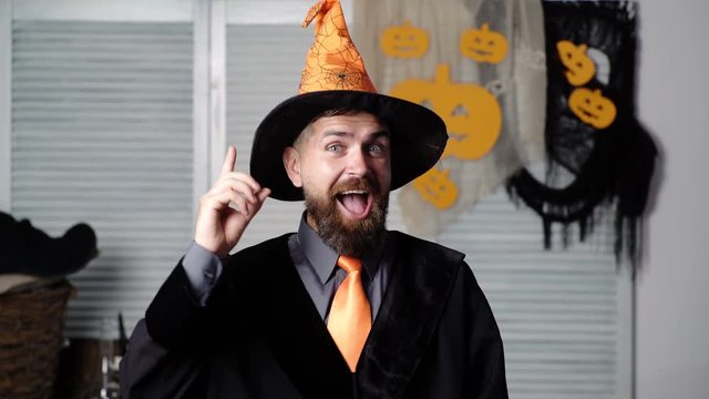 Happy Halloween story. A terrible tale at night. Good magician with a smile. Magician with a book. Reading at night. Halloween party background. Best father ever. Pumpkin on halloween background.