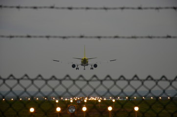 airplane landing on the runway at dusk