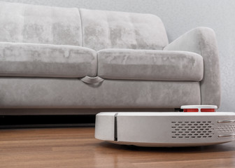 Robotic vacuum cleaner on laminate floor near sofa closeup, smart home robotics wireless cleaning...