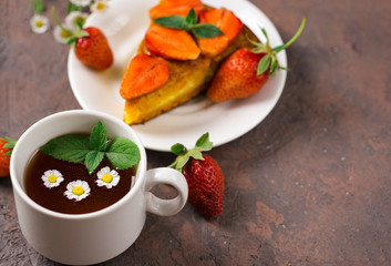 Carrot cake with strawberries and a Cup of chamomile tea. Summer delicious homemade dessert