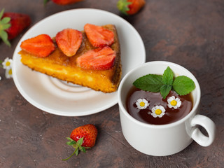 Carrot cake with strawberries and a Cup of chamomile tea. Summer delicious homemade dessert