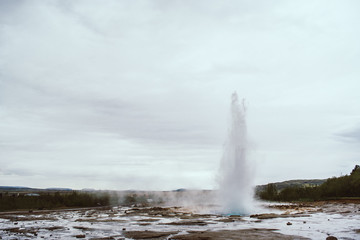 Stages of the eruption of the famous Strokkur Geyser In Iceland on a cold cloudy afternoon. Giant blue bubble right before the eruption
