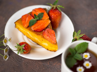 Carrot cake with strawberries and a Cup of chamomile tea. Summer delicious homemade dessert