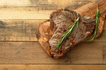 Marbled beef steak on rosemary board, on wooden background, restaurant menu, gastronomy, delicious food
