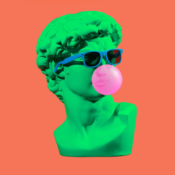 Statue. Earphone. Isolated. Gypsum statue of David's head. Man. Creative. Plaster statue of David's head in blue sunglasses. Minimal concept art.