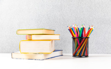 colorful pens on a desk with books