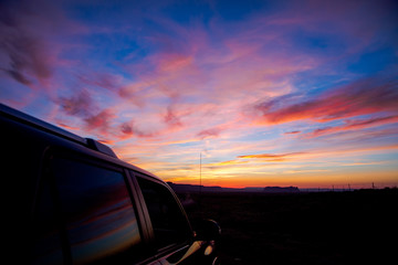 A colorful reflection on a car window at sunset in Monument Valley