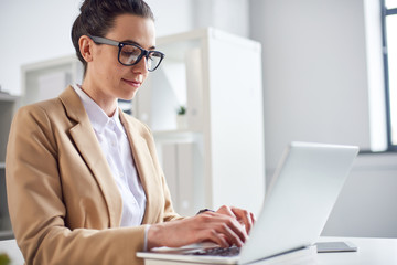 Mid age businesswoman working at the laptop in office