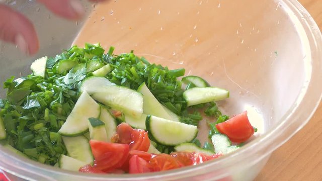 hands slice fresh tomato and cucumber salad